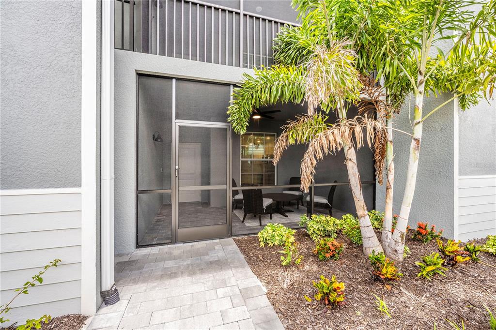 17500 Opal Sand Drive, Unit 101 Venice, FL 34293 - Photo 49 of 98 a backyard of a house with a garden and outdoor seating