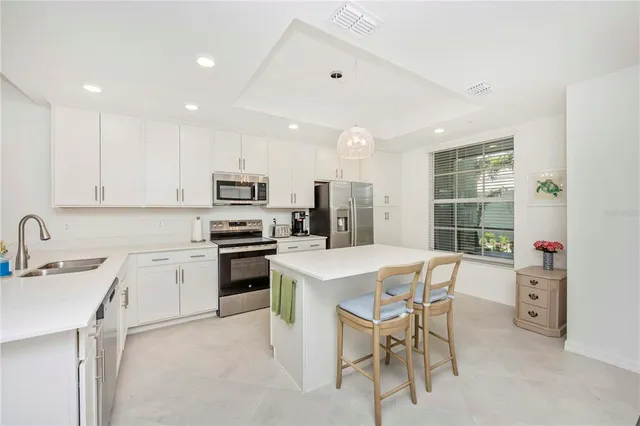 a kitchen with white cabinets and stainless steel appliances