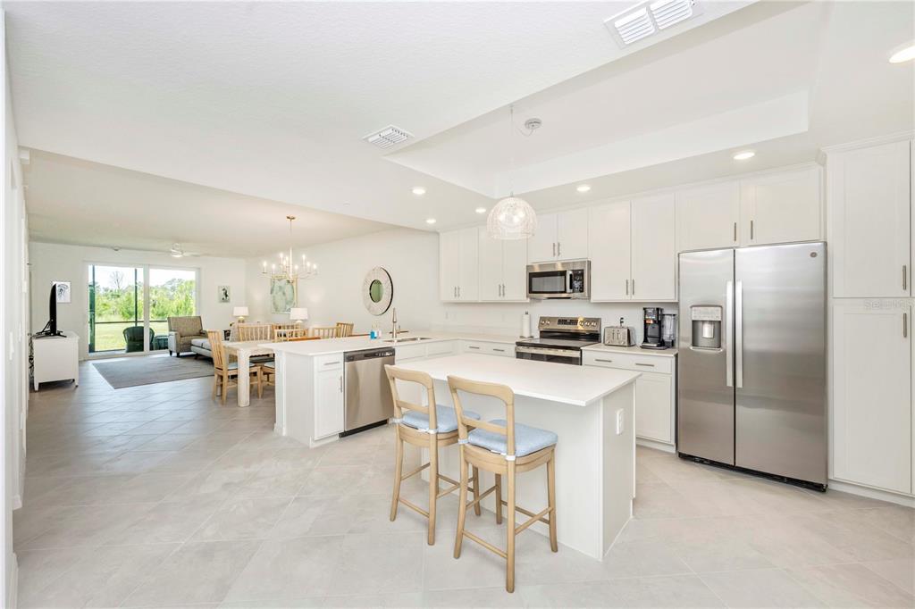17500 Opal Sand Drive, Unit 101 Venice, FL 34293 - Photo 8 of 98 a kitchen with white cabinets and stainless steel appliances