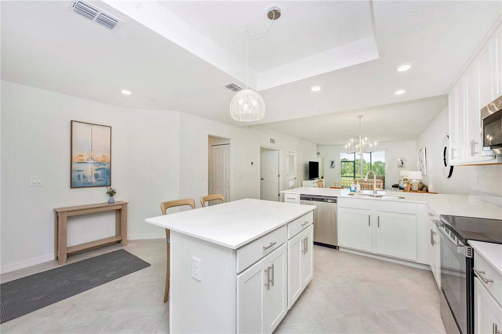 17500 Opal Sand Drive, Unit 101 Venice, FL 34293 - Photo 9 of 98 a kitchen that has a lot of white cabinets and stainless steel appliances