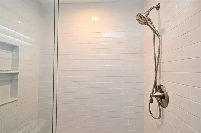 a bedroom with a bed and lamp on the dresser