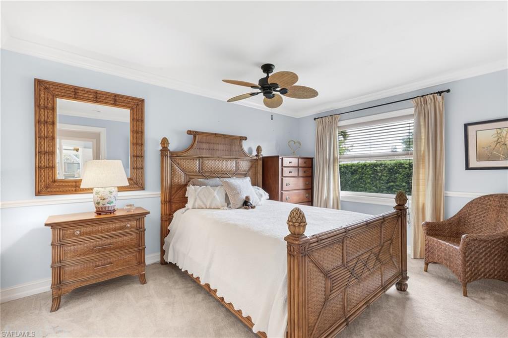 1904 Countess Court Naples, FL 34110 - Photo 21 of 33 a bedroom with a bed a chandelier and a dresser
