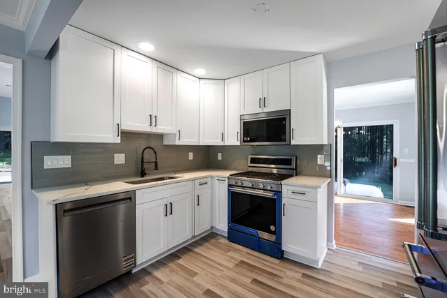 a kitchen with stainless steel appliances granite countertop a stove a sink and a microwave
