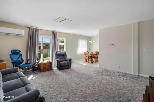 a dining room with chandelier and wooden floor