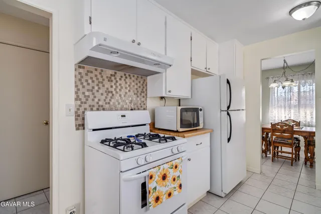 a kitchen with white cabinets and sink