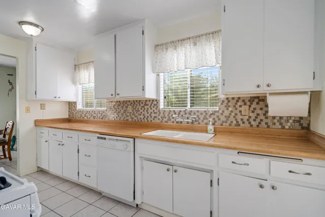 a kitchen with granite countertop a sink a counter space stainless steel appliances and cabinets