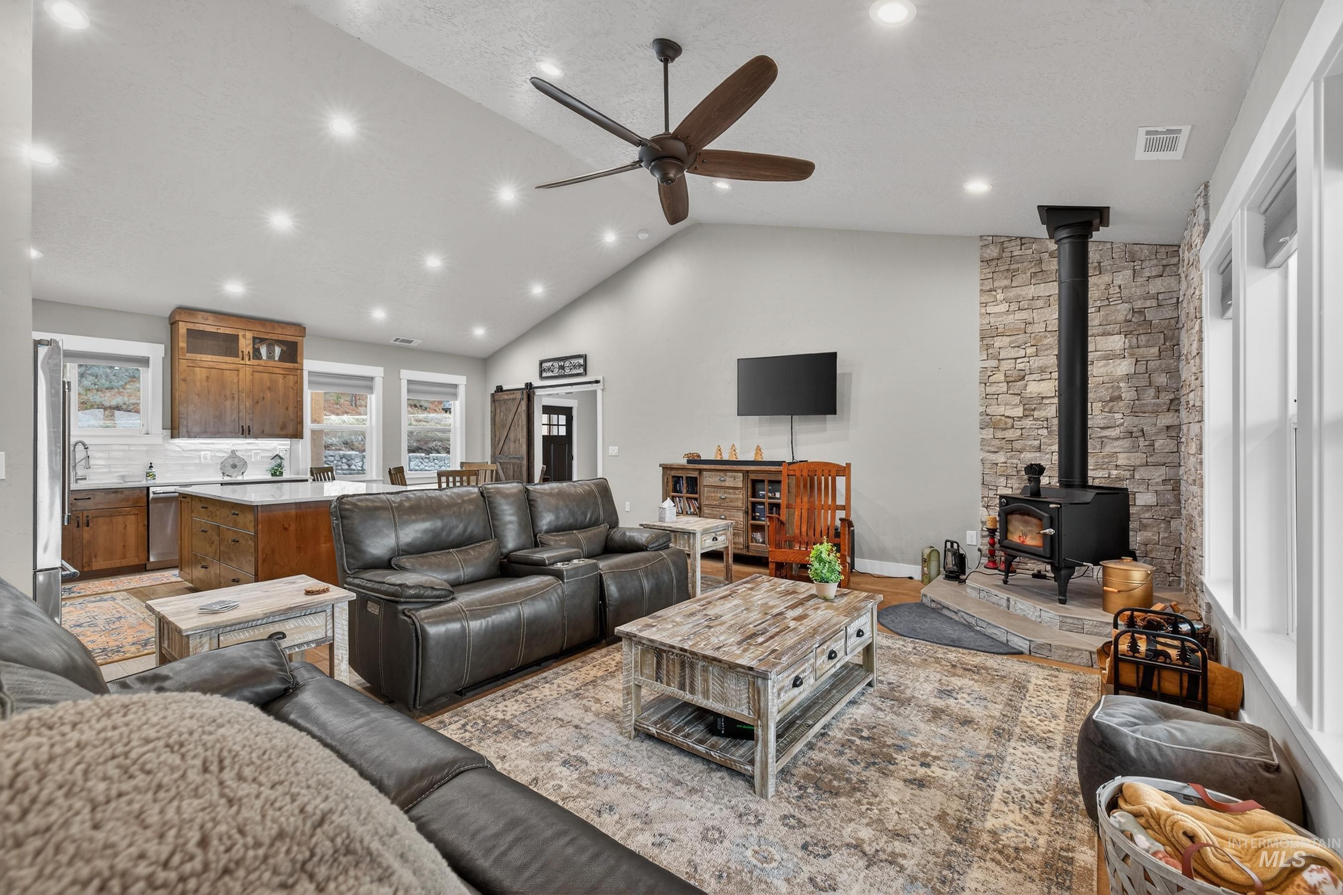 10191 Timberrim Drive Cascade, ID 83611 - Photo 1 of 44 Living area featuring ceiling fan, a wood stove, a high ceiling, and recessed lighting