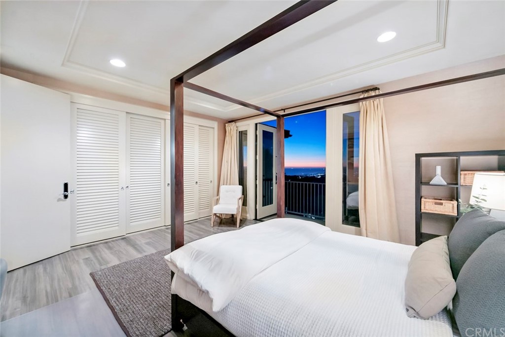 11 Vista Luci Newport Coast, CA 92657 - Photo 59 of 63 a bedroom with a large bed and wooden floor