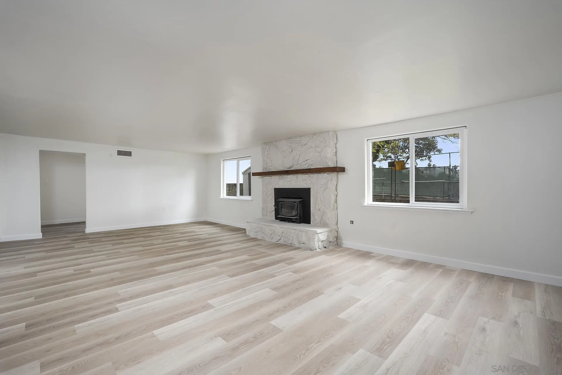 9213 Fenway Road Santee, CA 92071 - Photo 9 of 25 a view of empty room with wooden floor and fireplace
