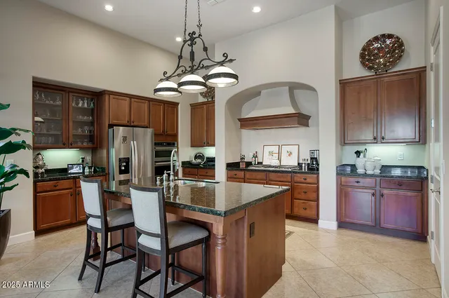 a kitchen with stainless steel appliances granite countertop a stove refrigerator a sink dishwasher with a dining table and chairs