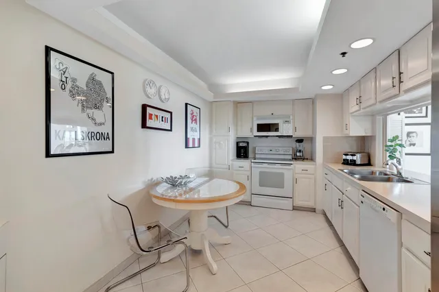 a kitchen with stainless steel appliances a white table and chairs in it
