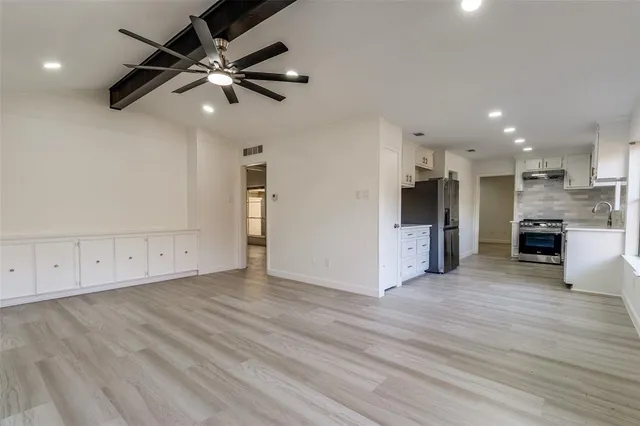 a view of a kitchen with a sink and a refrigerator