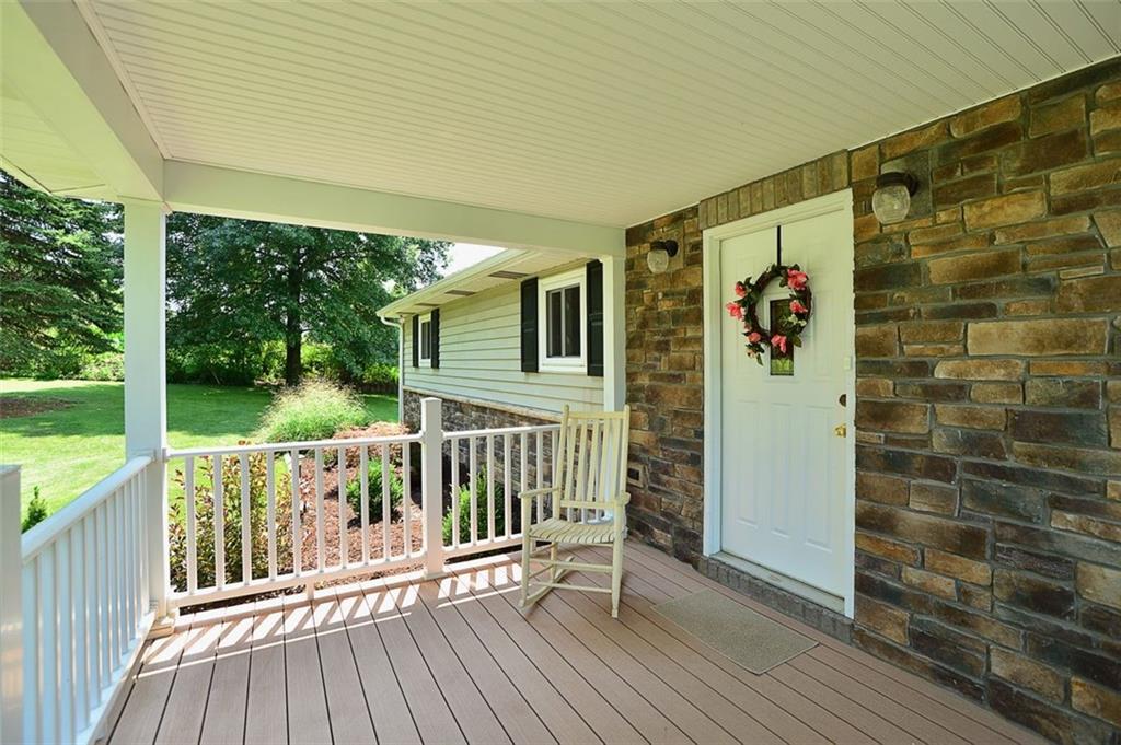 The Covered Front Porch features quality stone facia and maintenance free materials for years of enjoyment without all the upkeep!