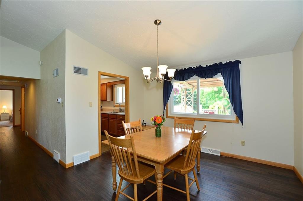 Dining area is adjacent to Living Room & Kitchen. Wood flooring leads to 5 bedrooms, 2 full baths, including the XL Master Suite.