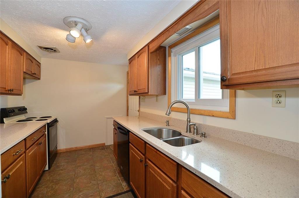 462 Scott Ridge Road Harmony, PA 16037 - Photo 8 of 25 The Galley kitchen has REAL OAK cabinets, Corian® countertops, Ceramic floor and Stainless sink. Kitchen also walks out (door is upper righthand in image) to the elevated rear deck w/ Pergola overlooking the private backyard.