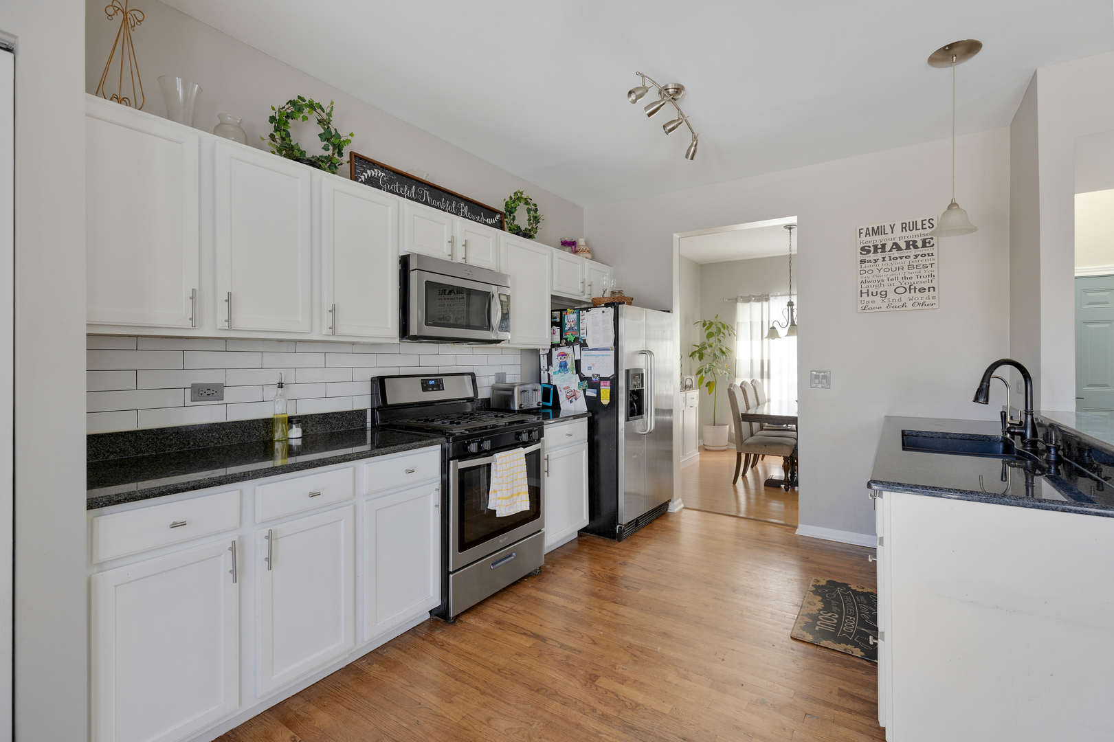 1 Carl Court Lake In The Hills, IL 60156 - Photo 5 of 20 a kitchen with stainless steel appliances white cabinets a sink a stove a microwave and wooden floors