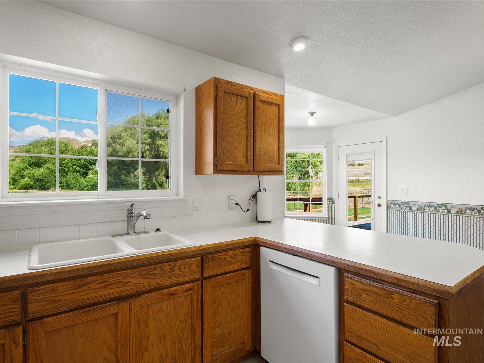 3540 Wills Road Emmett, ID 83617 - Photo 13 of 36 Kitchen featuring wood cabinetry, solid surface countertops, and a double basin sink with a chrome faucet