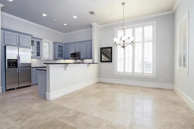 a kitchen with kitchen island a sink a counter top space stainless steel appliances and a window