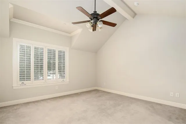 an empty room with a window and a ceiling fan