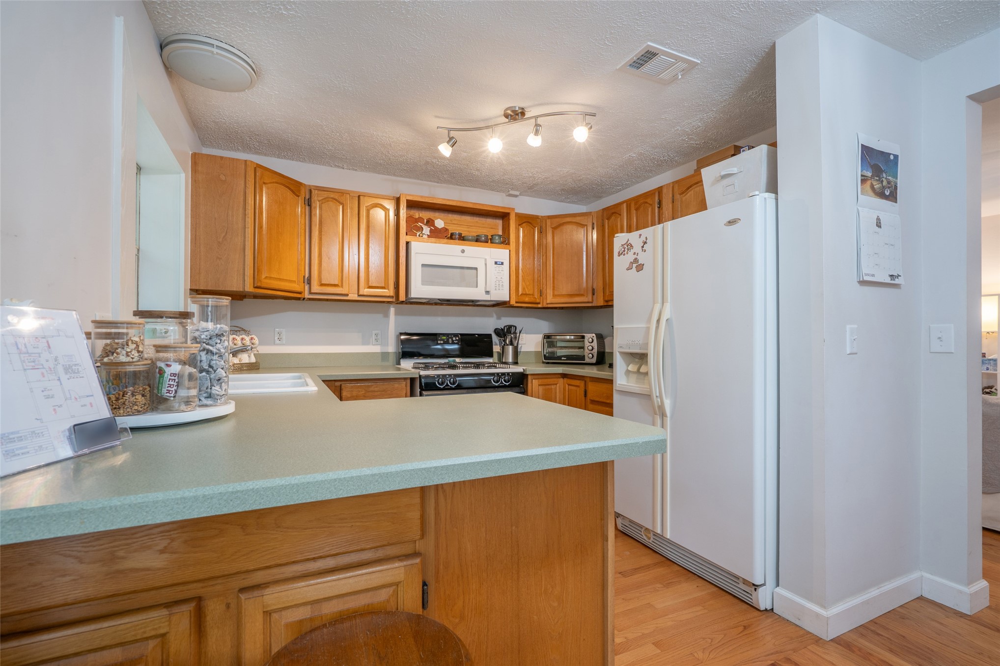 807 Stanley Drive Fernandina Beach, FL 32034 - Photo 12 of 30 a kitchen with a refrigerator a stove a sink a counter space and cabinets