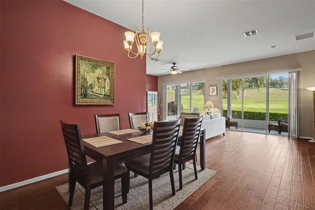 a view of a dining room with furniture a chandelier and wooden floor