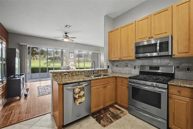 a kitchen with stainless steel appliances granite countertop a stove sink and microwave