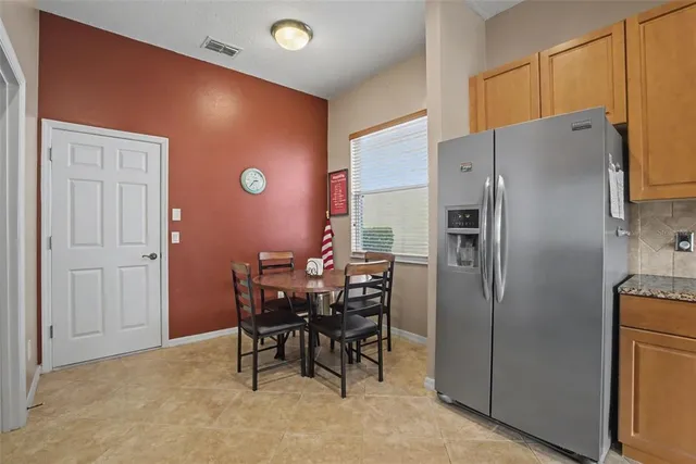 a kitchen with a refrigerator and table chair