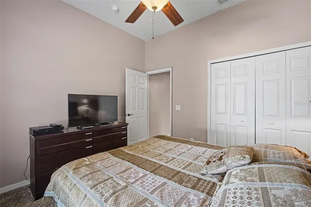 a bedroom with a bed and a flat tv screen on dresser