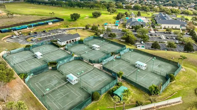 a view of a tennis ground with large trees
