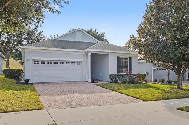 a view of a house with a yard and large tree