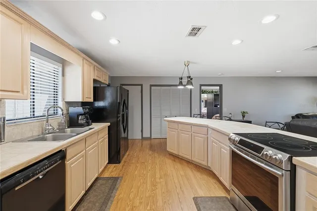 a kitchen with stainless steel appliances granite countertop sink stove top oven and cabinets