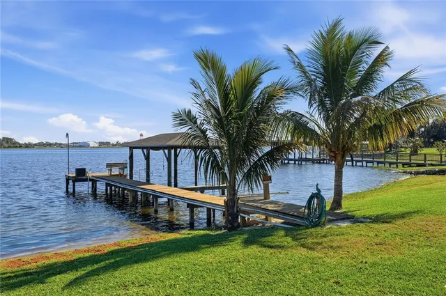 a view of a house with a big yard and large trees