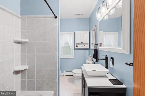 a bathroom with a sink a toilet and shower