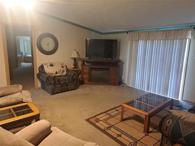 a living room with furniture a flat screen tv and a window