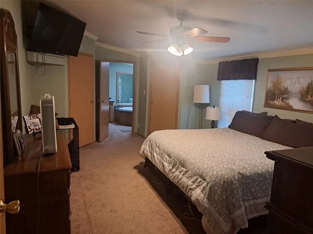 a bedroom with a bed a dresser and potted plants with the wooden floor