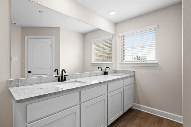 a bathroom with a granite countertop sink and a window
