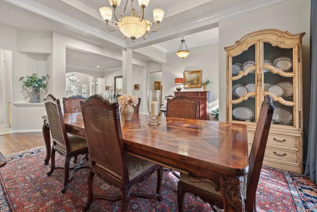a bedroom with a bed a large window with table and chairs