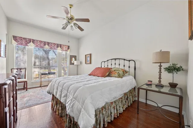 a view of a white house with a large tree next to a yard