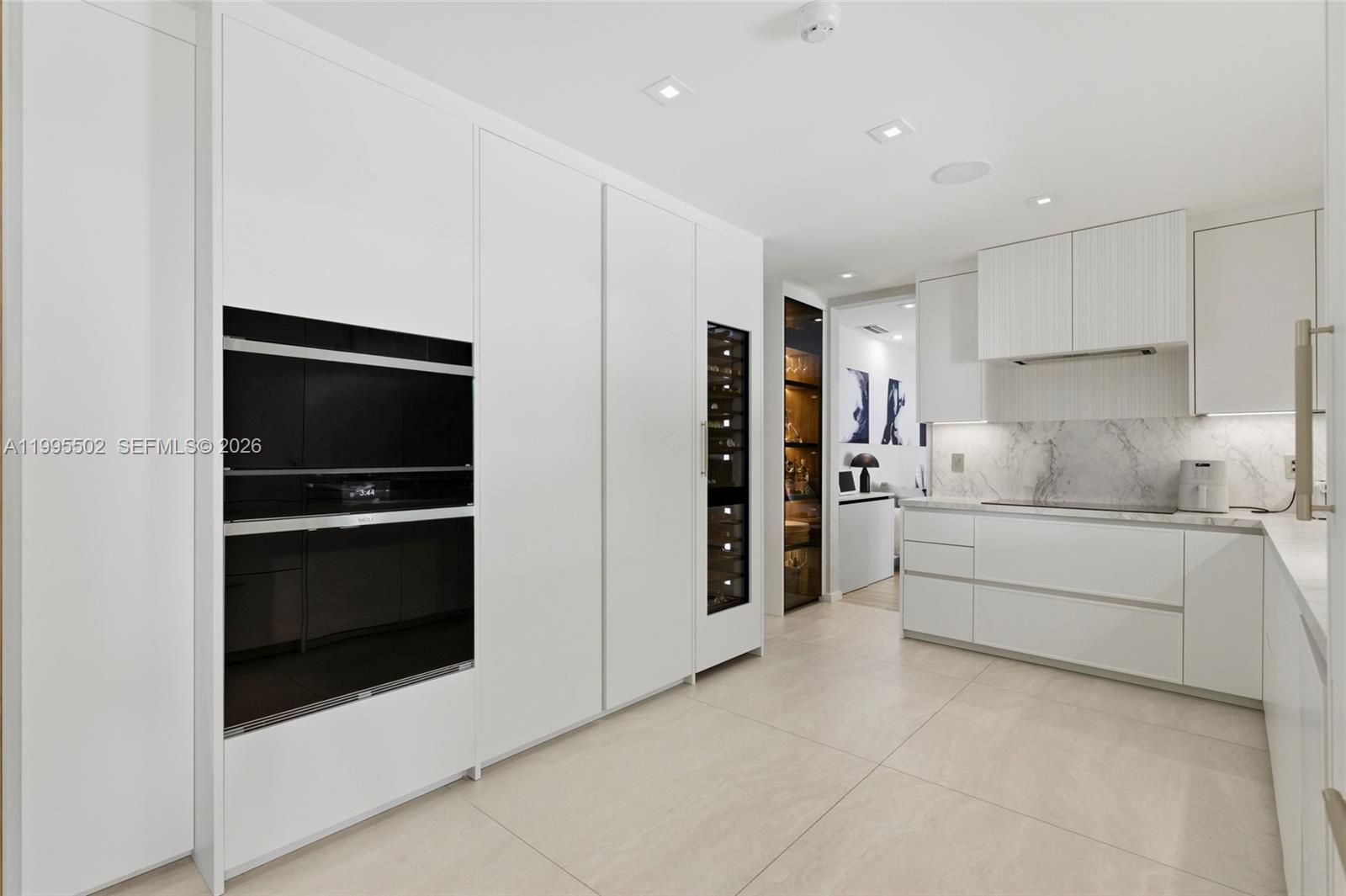 6449 Southwest 56th Street South Miami, FL 33155 - Photo 13 of 39 a kitchen with stainless steel appliances a refrigerator stove and white cabinets