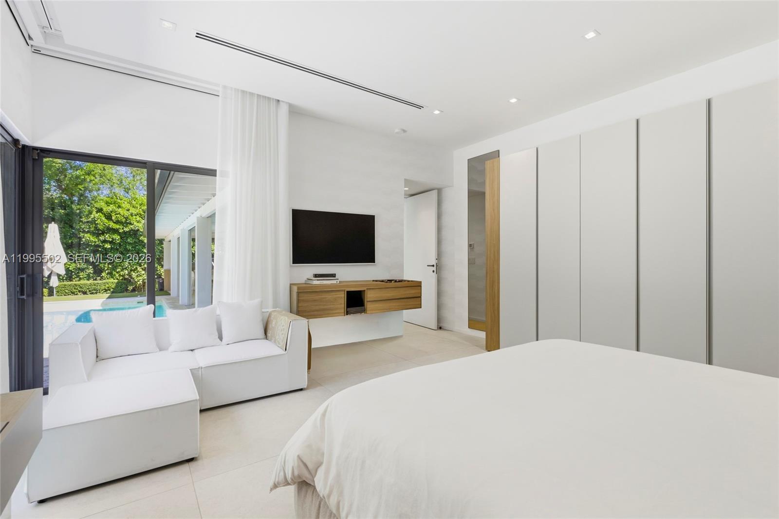 6449 Southwest 56th Street South Miami, FL 33155 - Photo 30 of 39 a bedroom with furniture white walls and flat screen tv