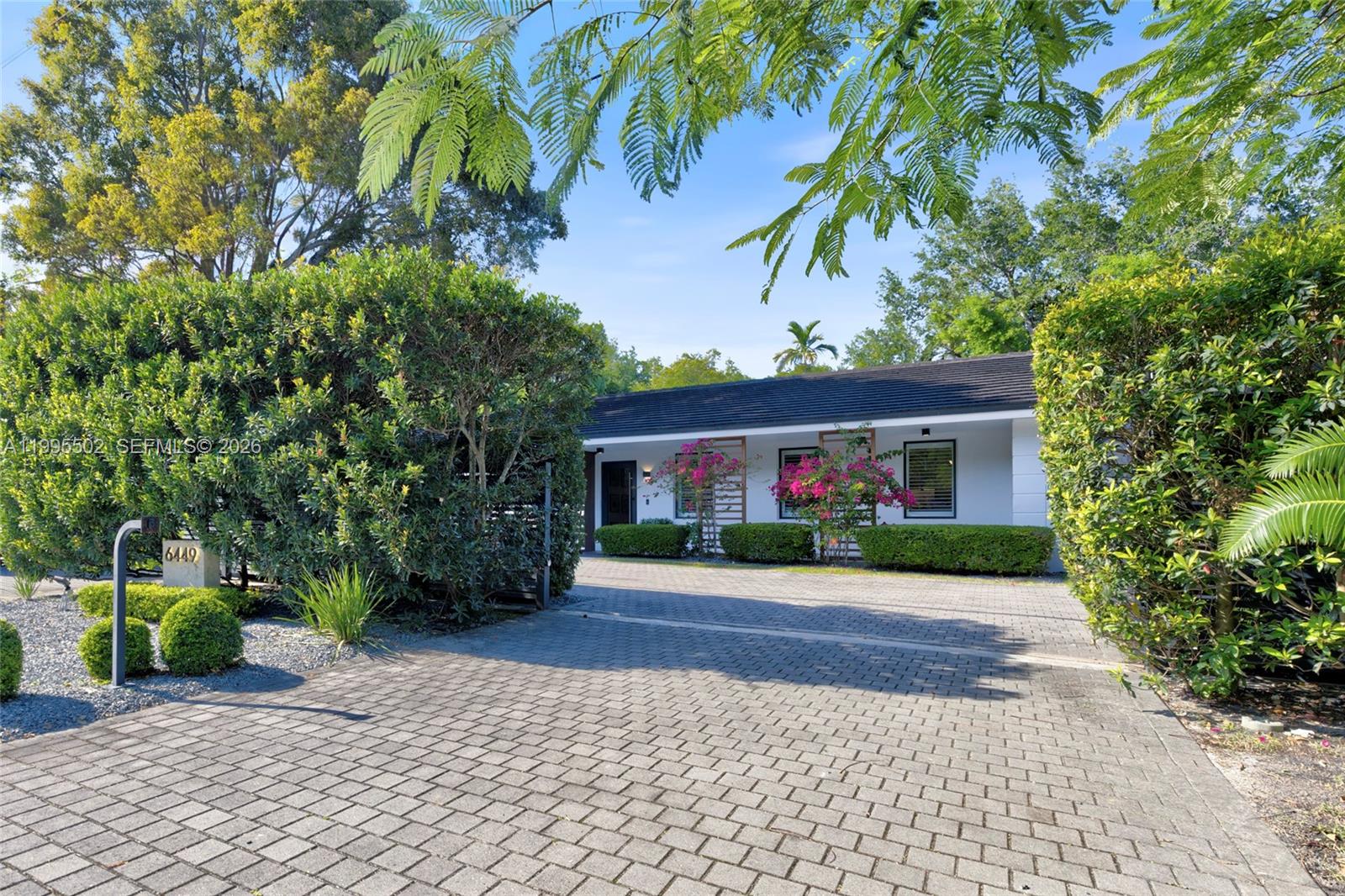 6449 Southwest 56th Street South Miami, FL 33155 - Photo 3 of 39 a front view of a house with a yard and a garage