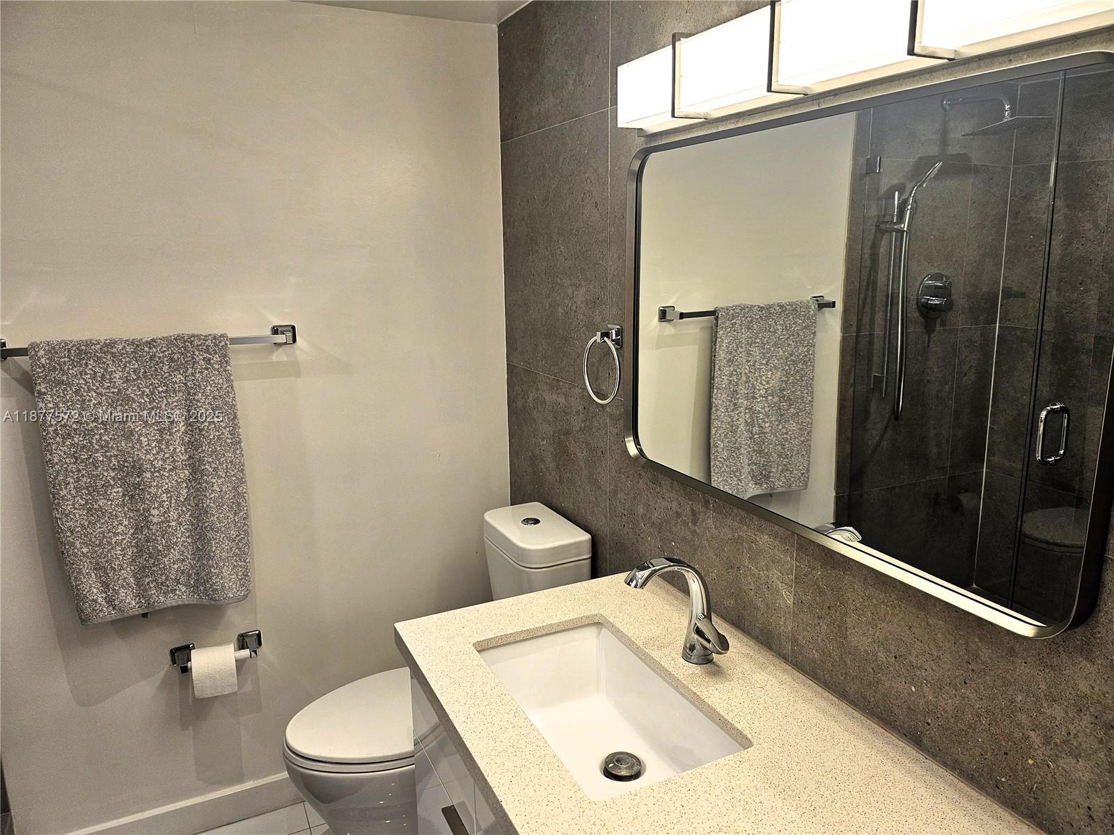 5161 Collins Avenue, Unit 707 Miami Beach, FL 33140 - Photo 14 of 69 a bathroom with a sink a toilet and shower