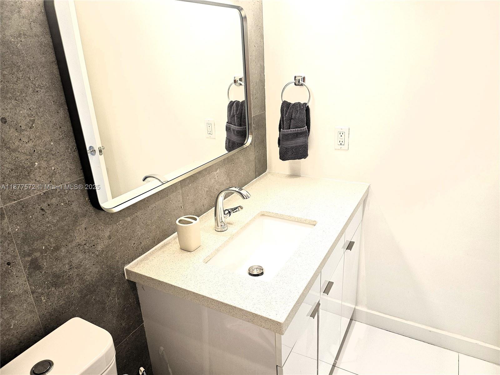 5161 Collins Avenue, Unit 707 Miami Beach, FL 33140 - Photo 19 of 69 a bathroom with a sink mirror and toilet