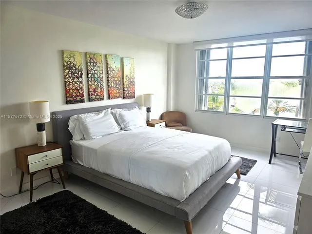 a bedroom with two beds and a chair