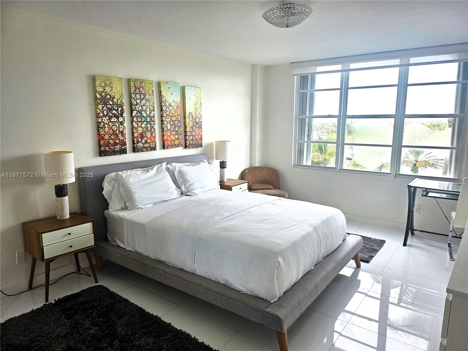 5161 Collins Avenue, Unit 707 Miami Beach, FL 33140 - Photo 20 of 69 a bedroom with a bed lamps and window