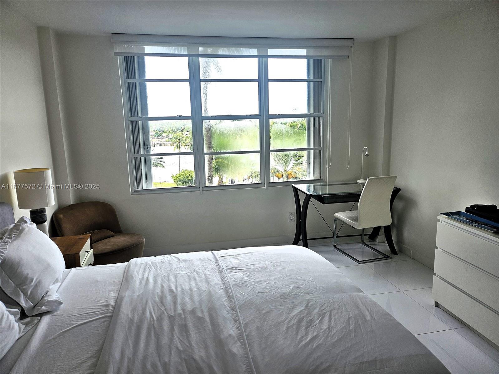 5161 Collins Avenue, Unit 707 Miami Beach, FL 33140 - Photo 21 of 69 a bedroom with two beds and a chair