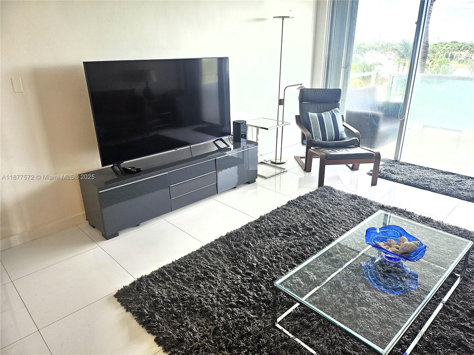 5161 Collins Avenue, Unit 707 Miami Beach, FL 33140 - Photo 27 of 69 a living room with a flat screen tv and a couch