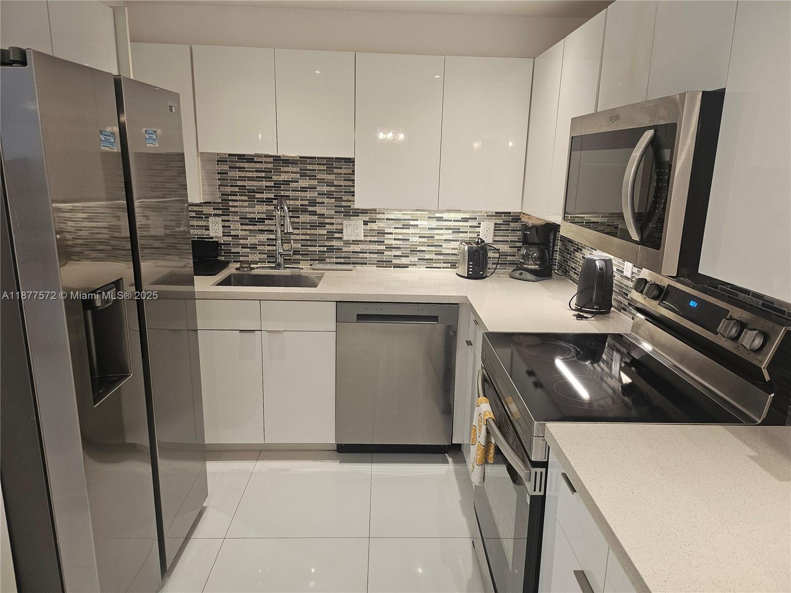 5161 Collins Avenue, Unit 707 Miami Beach, FL 33140 - Photo 8 of 69 a kitchen with a sink stove and refrigerator