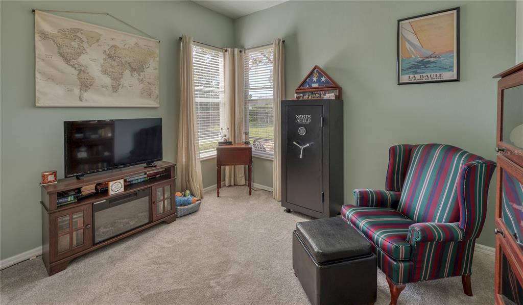 3473 Conifer Loop Spring Hill, FL 34609 - Photo 25 of 33 a living room with furniture a flat screen tv and a fireplace