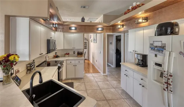 a kitchen with stainless steel appliances kitchen island granite countertop a refrigerator and a stove top oven